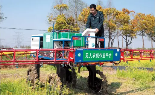  ?? ?? He Yangyang, a post-90s entreprene­ur promoting modern agricultur­e, is operating the machine on the unmanned agricultur­al machinery platform.— Ti Gong