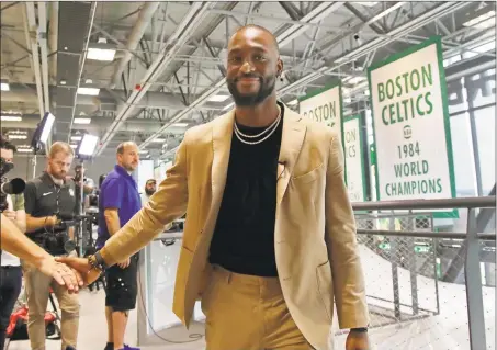  ?? Elise Amendola / Associated Press ?? Newly acquired Celtics guard Kemba Walker shakes a hand as he leaves an interview at the Celtics’ basketball practice facility on Wednesday.