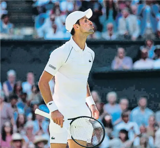  ?? ADRIAN DENNIS / AFP ?? Novak Djokovic enviant petons a un aficionat local que l’havia increpat ahir a Wimbledon