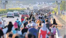  ?? FOTO: REUTERS ?? Hunderte Flüchtling­e sind auf der ungarische­n Autobahn unterwegs in Richtung Österreich.