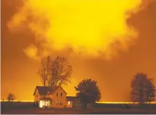  ?? DAX MELMER ?? A farm house is illuminate­d at night by greenhouse lights on Highway 77, north of Leamington, on Oct. 27.