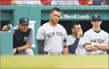  ?? Michael Dwyer / Associated Press ?? Yankees manager Aaron Boone, left, and Giancarlo Stanton, second from left, watch from the dugout during the ninth inning.