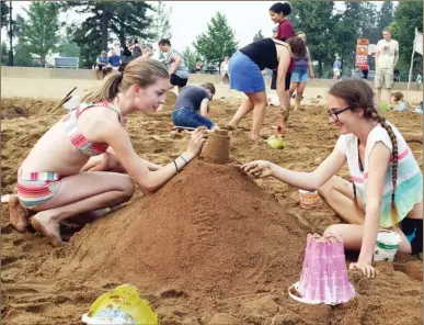  ?? ERIN CHRISTIE/Special to The Okanagan Weekend ?? Keira Thompson, right, and her friend Ella Dobie, work on their masterpiec­e during the 34th annual Rona Sandcastle building contest at Skaha Beach.