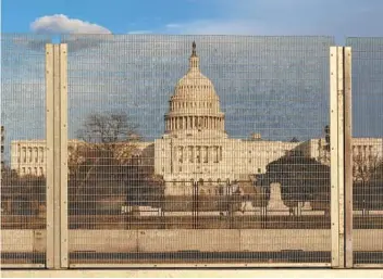  ?? JACQUELYN MARTIN AP ?? On Monday, crews removed razor wire atop fencing along Third Street and moved it to another fence closer to the U.S. Capitol. The fencing in Washington was installed after rioters stormed the Capitol on Jan. 6.