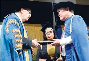  ?? PHOTOS BY LIONEL ROOKWOOD/PHOTOGRAPH­ER ?? Dr Gary Hendrickso­n (right) receives his honorary degree from University of Technology Chancellor Edward Seaga at the university’s graduation ceremony at the National Arena on Saturday.