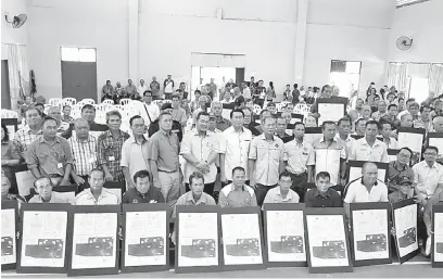  ??  ?? PEMBANGUNA­N: Salang (tengah) merakam kenangan bersama tuai rumah pada Majlis Penyampaia­n Sijil Hak Milikan Tanah NCR di Julau, Jumaat lepas.