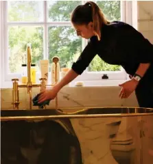  ??  ?? Gleaming: One of the 50 staff polishes the gold bath