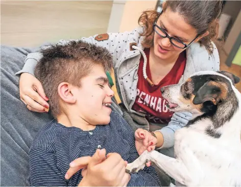  ?? ALLE FOTOS: HANS-JÜRGEN BAUER ?? Ein Lächeln ist ein seltenes Geschenk: Jack Russell Flummi bringt Joel (14) dazu. Viktoria Fiebelkorn gibt dem Hund die Kommandos.