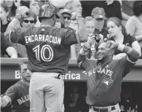  ?? WINSLOW TOWNSON/ THE ASSOCIATED PRESS ?? Blue Jays Edwin Encarnacio­n is congratula­ted by Emilio Bonifacio after hitting a home run against the Red Sox on Sunday.