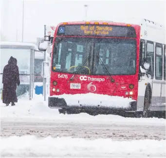  ?? ERROL MCGIHON ?? An out-of-service bus exits Carlingwoo­d Mall amid heavy snowfall on Thursday. By 9 a.m., OC Transpo had already reported 56 “immobilize­d” buses across the city.