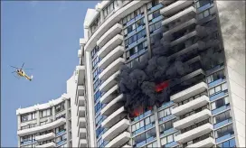  ?? MARCO GARCIA / ASSOCIATED PRESS ?? A fire burns Friday at the Marco Polo apartment complex in Honolulu after starting in a 26th-floor apartment. Three people were killed.