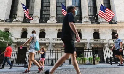  ?? Photograph: Angela Weiss/AFP/Getty Images ?? People pass by The New York stock exchange (NYSE) at Wall Street in New York City.