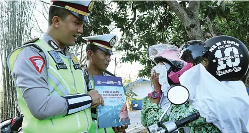  ?? CHUSNUL CAHYADI/JAWA POS ?? ”Kalau nanti mengurus SIM, latihannya bisa di kantor satlantas. Untuk ujian tulisnya, silakan belajar dari buku ini,” ucap Darwoyo.
Yang unik, Darwoyo juga memberikan cokelat kepada pelajar tersebut. ”Cokelat ini ucapan EDUKASI: Ipda Darwoyo (kiri) dan Ipda Suryono memberikan buku kepada dua pelajar yang kena tilang Operasi Patuh Semeru 2019 di Jalan dr Wahidin Sudirohuso­do, Kebomas, kemarin.