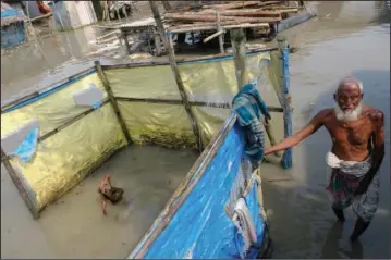  ?? ?? An elderly man stands by a tube well buried in water Oct. 5 during high tide in Satkhira.