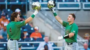  ?? JOHN PETERSON/AP ?? Notre Dame’s Jared Miller, right, celebrates his home run with Carter Putz during the first inning of a College World Series game against Texas on Friday in Omaha, Neb. The Irish won 7-3.