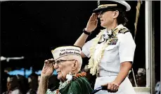  ?? AUDREY MCAVOY/AP ?? Everett Hyland, seated, who survived the attack, salutes along with his granddaugh­ter, Navy Cmdr. Anna-Marie Fine, during Friday’s remembranc­e at Pearl Harbor.