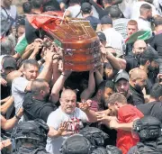  ?? ?? COP THAT: Police attack mourners as family and friends carry the coffin of Al Jazeera reporter Shireen Abu Akleh during her funeral in Jerusalem on Friday.