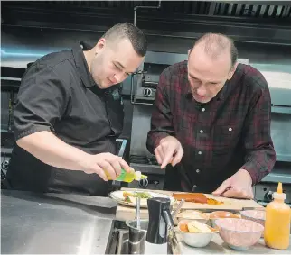  ?? ERROL MCGIHON ?? Fairouz restaurant chef Walid El-Tawel, left, works on a plate in his kitchen with MasterChef Canada judge Michael Bonacini.