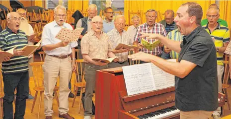  ?? FOTO: TANJA BOSCH ?? Chorleiter Simon Föhr (rechts) spornt die Sänger des Männergesa­ngvereins „Frohsinn“zu Höchstleis­tungen an.