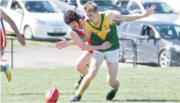  ??  ?? Garfield’s Joseph Verleg has his run at the ball impeded by Phillip Island’s Matthew Freeman; Photograph­s: Michael Robinson.