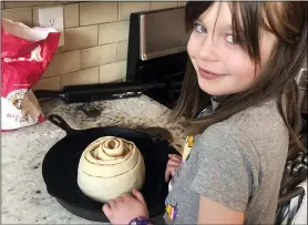  ?? WHITNEY RUTZ VIA AP ?? Elsa Rutz poses by a cinnamon roll April 5at home in Portland, Ore..