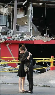  ?? (File Photo/AP/Hans-Maximo Musielik) ?? Family members of a victim of the deadly arson attack on the Casino Royale embrace Aug. 27, 2011, in front of the charred gambling house in Monterrey.