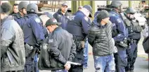  ??  ?? CUFF GUYS: Police handcuff suspects outside a Brooklyn motorcycle club after a man was pistol-whipped Saturday.