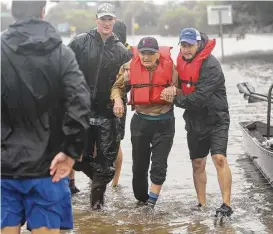  ?? Mark Mulligan / Houston Chronicle ?? Volunteers bring 96-year-old Art Kolten to safety Monday after evacuating him out of his Meyerland home along North Braeswood near Interstate 610.