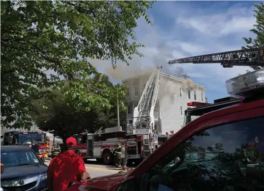  ?? MARy sCHwALm PHOTOs / BOsTOn HeRALd ?? Firefighte­rs battle a fire at 93 Temple St. in Somerville on Friday. No one was injured by the home suffered considerab­le damage.