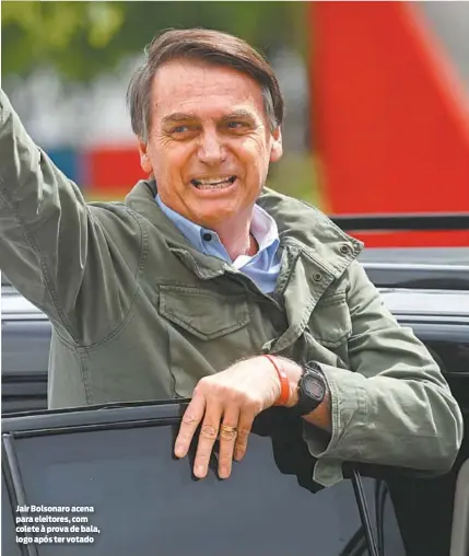  ?? MAURO PIMENTEL/AFP ?? Jair Bolsonaro acena para eleitores, com colete à prova de bala, logo após ter votado