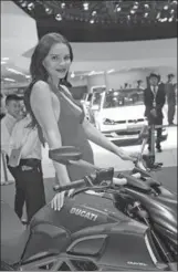  ?? DONG NING / FOR CHINA DAILY ?? A model stands beside a Ducati motorcycle during a recent motor fair in Beijing. Ducati is bringing more of its models to China.