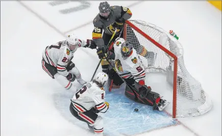  ?? Jason Franson The Associated Press ?? Alex Tuch jams his rebound past Corey Crawford for the game-winner as Adam Boqvist (27) and Duncan Keith fail to defend.
