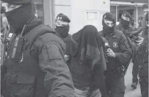  ??  ?? Photo d’archives de la police espagnole procédant à l’arrestatio­n de jihadistes présumés à Barcelone, le 25 avril 2017