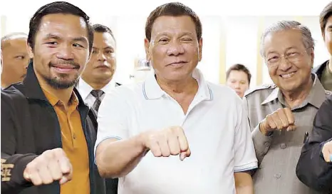  ??  ?? President Duterte flashes his signature pose with Malaysian Prime Minister Mahathir Mohamad and boxing icon Manny Pacquiao following the fight at the Axiata Arena in Kuala Lumpur on Sunday.