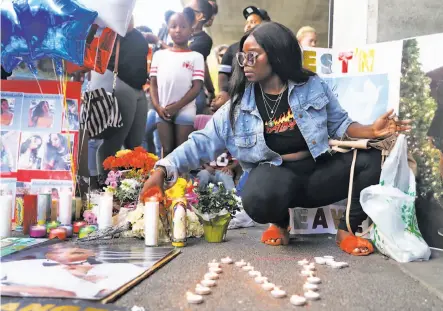  ?? Photos by Scott Strazzante / The Chronicle ?? Deja Bellamy places a candle in memory of her friend Nia Wilson, who was stabbed to death at the MacArthur BART Station.