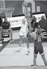  ??  ?? Oklahoma's Alondes Williams (15) dunks as Kansas State's Antonio Gordon (11) watches during the first half.
