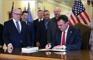  ?? SARAH PHIPPS — THE OKLAHOMAN VIA AP ?? Oklahoma Gov. Kevin Stitt signs an executive order in the Blue Room at the state Capitol in Oklahoma City, Wednesday, Dec. 13, 2023. In Oklahoma, Republican Gov. Kevin Stitt signed an executive order in December barring state agencies and universiti­es from spending money diversity initiative­s.