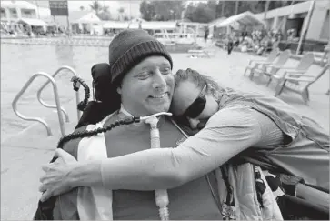  ??  ?? LARSEN gets a hug from Kelly Kerns of Van Nuys. This fall at UCLA, a surgeon will replace the damaged nerve to Larsen’s diaphragm with an intact one, so that one day he might be able to breathe on his own.