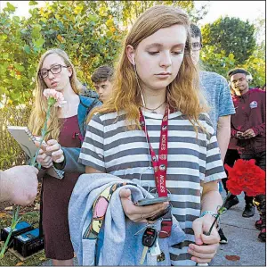  ?? AP/Miami Herald/MATIAS J. OCNER ?? Wednesday as they return to class at Marjory Stoneman Douglas High School in Parkland, Fla., for the first time since a gunman killed 14 students and three staff members with an AR-15 two weeks ago. Along with supporters, law enforcemen­t officers were...