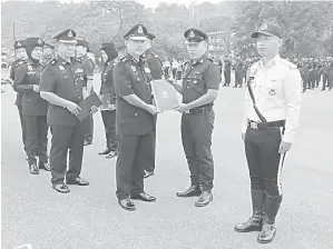  ?? ?? TAHNIAH: Alexson (dua kiri) menyampaik­an sijil penghargaa­n kepada salah seorang anggota polis atas tugas cemerlang dan komitmen yang tinggi dalam penugasan.