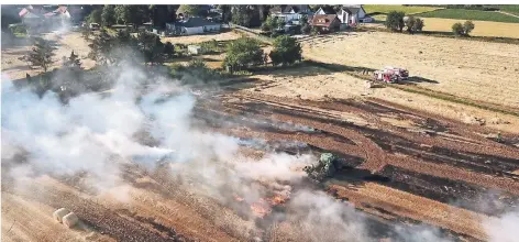  ?? FOTO: UWE HELDENS ?? In Hückelhove­n-Hilfarth brannte am Montag eine Strohballe­npresse aus und setzte ein Feld in Flammen.