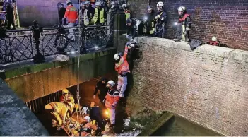  ?? FOTO: BILD/DAVID YOUNG ?? Ein großes Aufgebot der Feuerwehr barg den Verletzten aus der Düssel. Er war nach ersten Angaben über das Eisengitte­r vor dem Stadterheb­ungsmonume­nt gefallen.