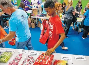  ?? AILEEN PERILLA/STAFF PHOTOGRAPH­ER ?? Wendy Simon, 15, an incoming freshman at Oak Ridge High School, volunteers Tuesday at nonprofit A Gift for Teaching’s backpack-stuffing event, which filled more than 700 backpacks.