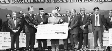  ??  ?? Taib (fourth left) presents a mock cheque to DBNA, represente­d by its treasurer general Asem Linkin (third right). Also seen are (from second left) Lau and Awang Tengah.