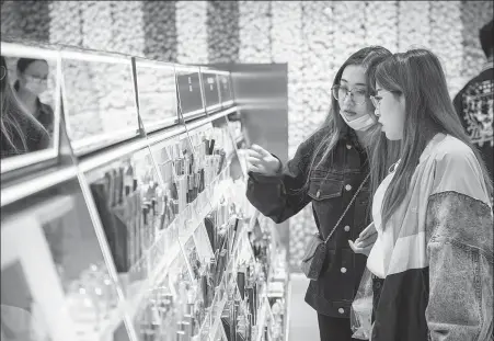  ??  ?? Top: Visitors check out makeup products at an outlet of The Colorist in Shanghai in October.