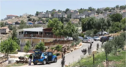  ?? (Marc Israel Sellem/The Jerusalem Post) ?? RESIDENTS UNLOAD items from a car in Elon Moreh last June.