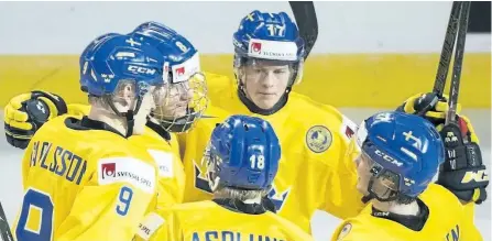  ?? GRAHAM HUGHES/CANADIAN PRESS ?? Sweden’s Rasmus Dahlin (in face mask) celebrates with teammates Fredrik Karlstrom (17), Gabriel Carlsson (9), Rasmus Asplund (18) and Jonathan Dalen after scoring against Denmark during Sweden’s boxing day game at the world juniors. The 16-year-old has...