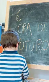  ??  ?? Alla lavagna Un bambino durante le attività educative