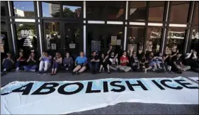  ??  ?? Protestors block the entrance to a downtown federal building housing Immigratio­n and Customs Enforcemen­t (ICE) offices on Monday, in San Diego. People protested against ICE on Monday, chanting slogans and temporaril­y blocking an entrance to a federal...