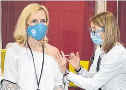  ?? DAVE STEWART • THE GUARDIAN ?? Deanne Burnet, right, a registered nurse, administer­s the Pfizer vaccine to Dr. Heather Morrison, left, P.E.I.’s chief public health officer, at the mass vaccinatio­n clinic in Charlottet­own on Thursday.